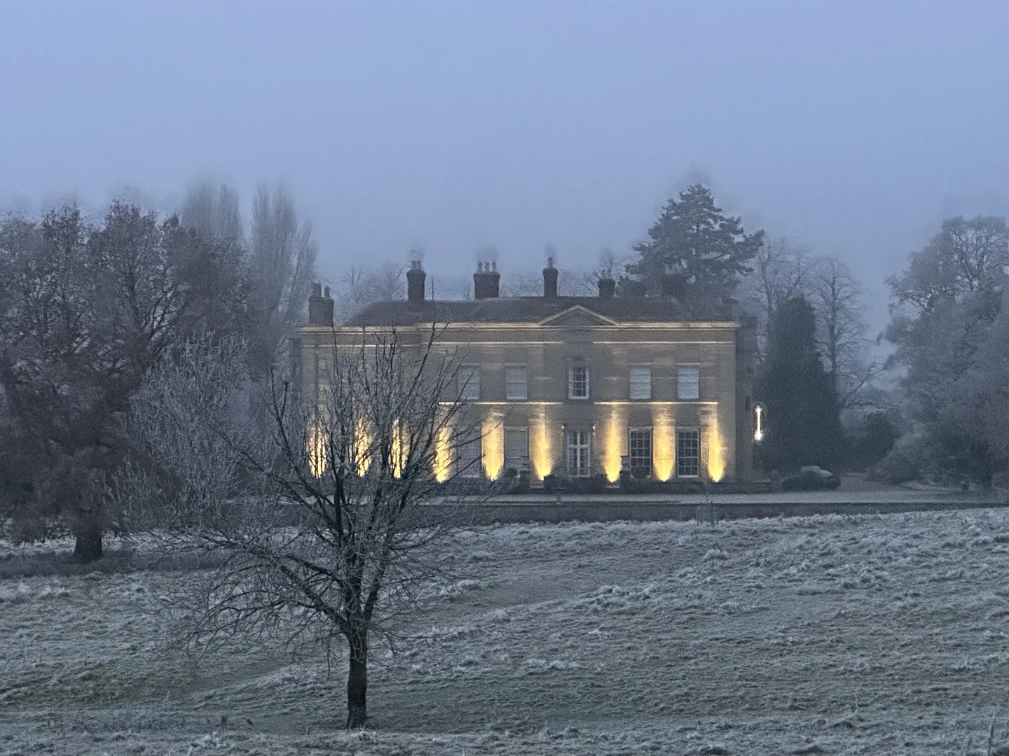 Barton Park Hall floodlit on a frosty, misty winter morning